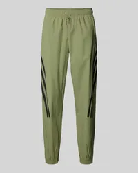 adidas Tapered Fit Sweatpants mit labeltypischen Streifen Oliv