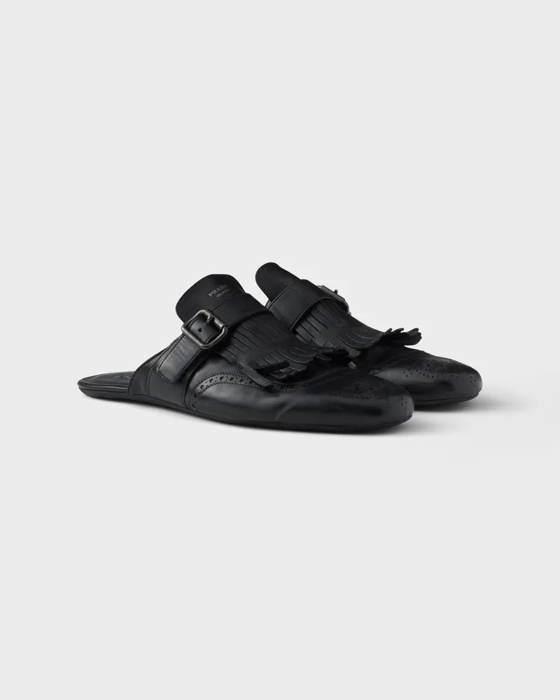 Prada Shuffle Mules aus Leder in Antik-Optik mit Riemen, Schließe und Fransen Schwarz